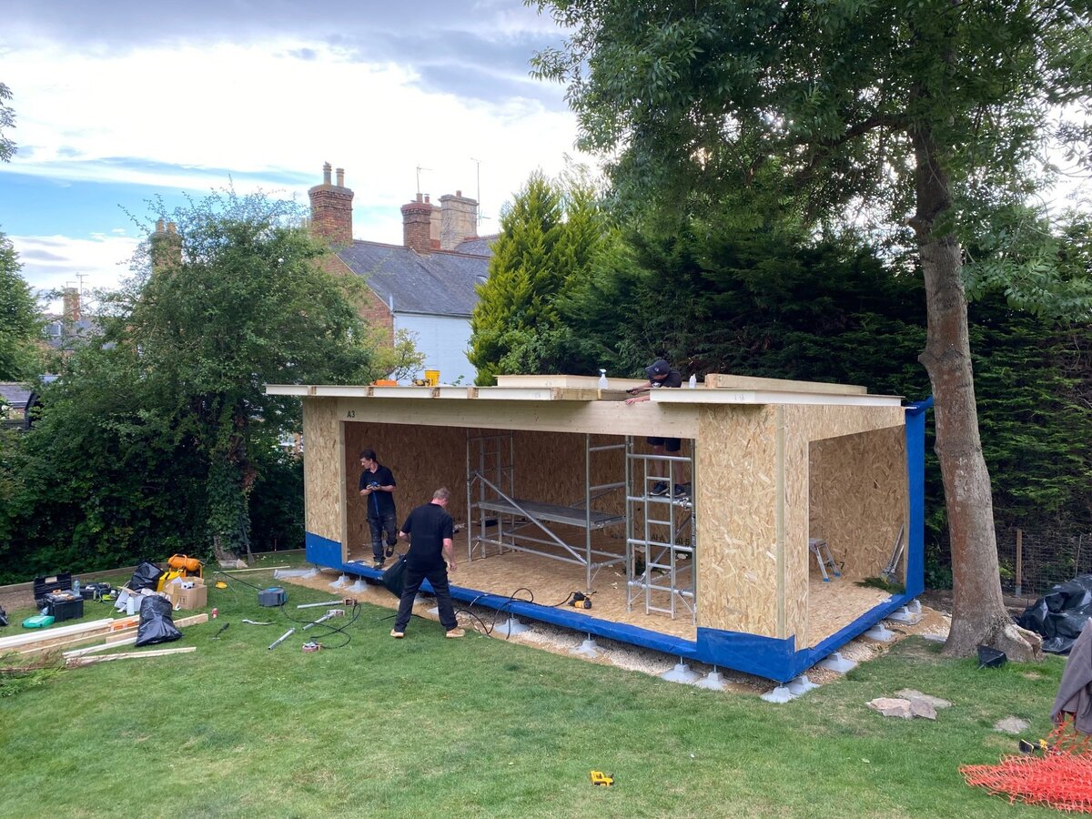 Garden room floor platform with two men working