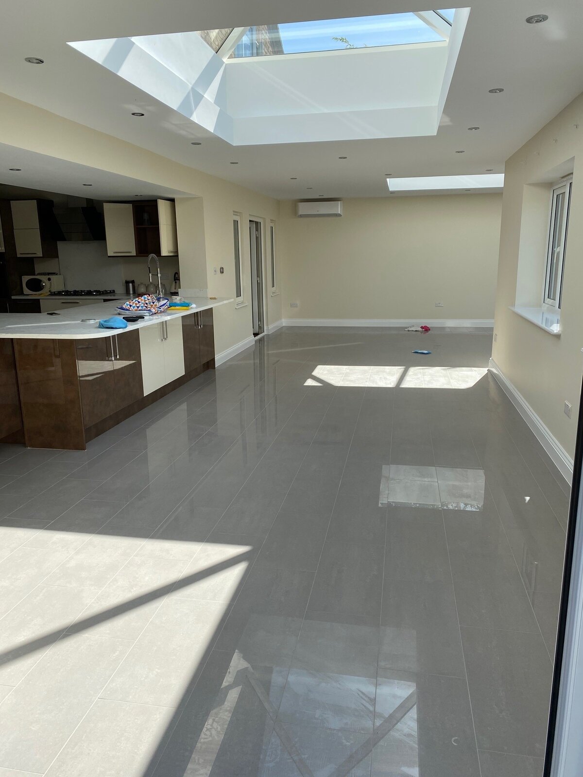 Open plan kitchen and living space with large format tiles and lantern roof