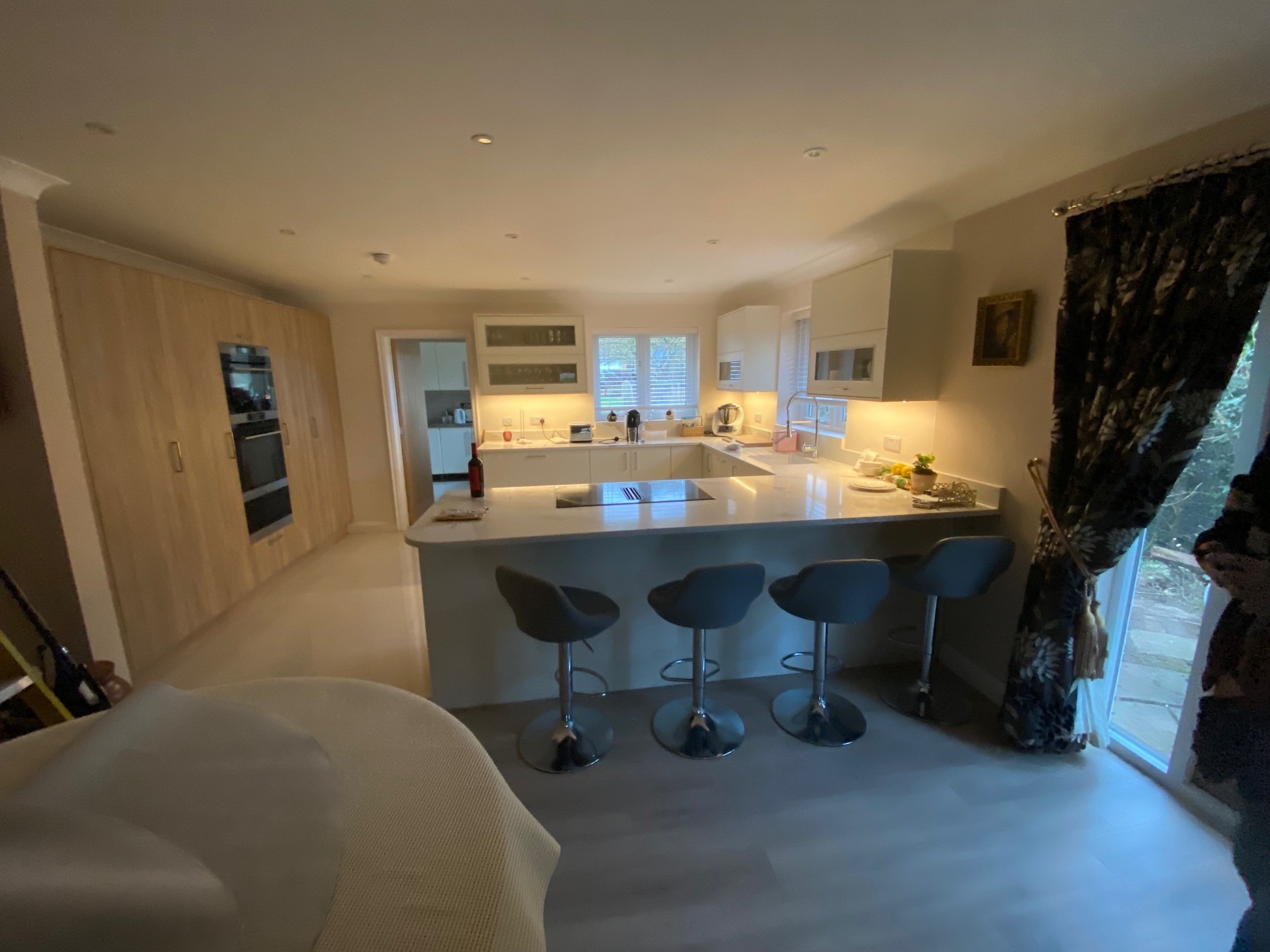 Open plan kitchen with peninsula, under-cabinet lighting and bifold doors