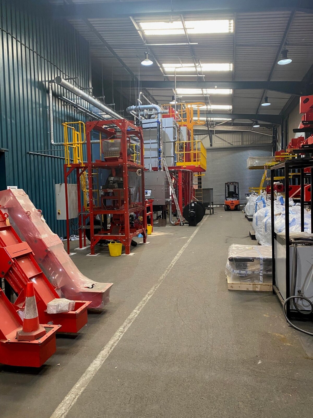 Industrial facility interior with machinery and forklift